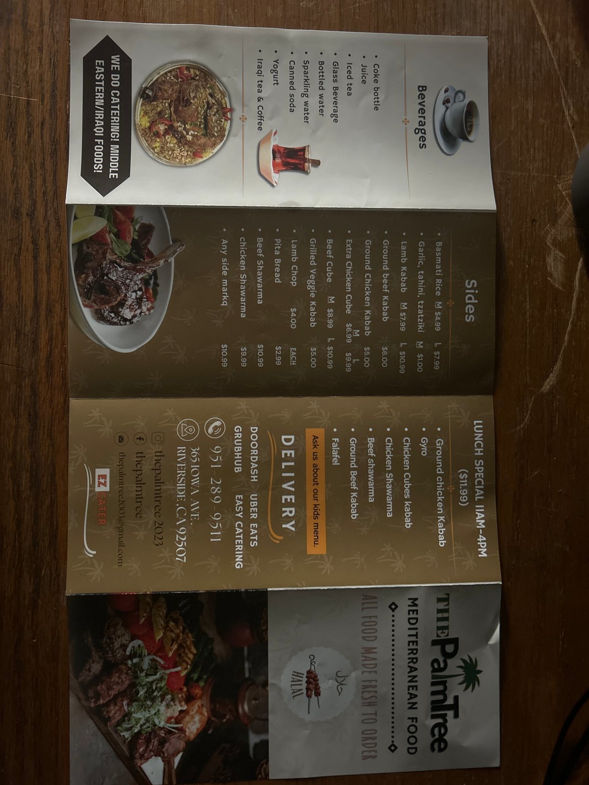 Multiple restaurant menus and takeout materials laid on a wooden table, including specialty cuisine options and drink selections