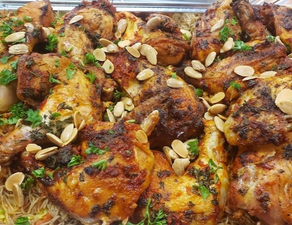 Golden-brown roasted chicken pieces topped with sliced almonds and fresh parsley garnish
